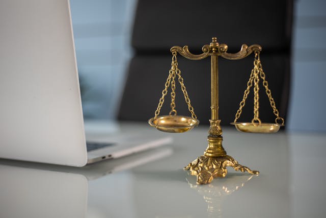 A golden balance scale beside a laptop