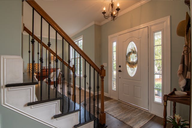 inside of house with staircase and front door with a wreath on it