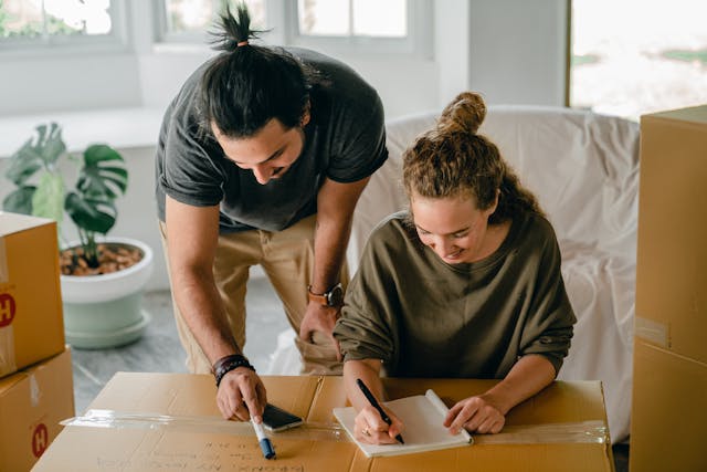 couple writing on moving boxes