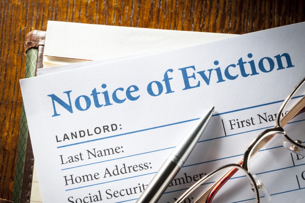 Glasses and a pen sitting on a notice of eviction
