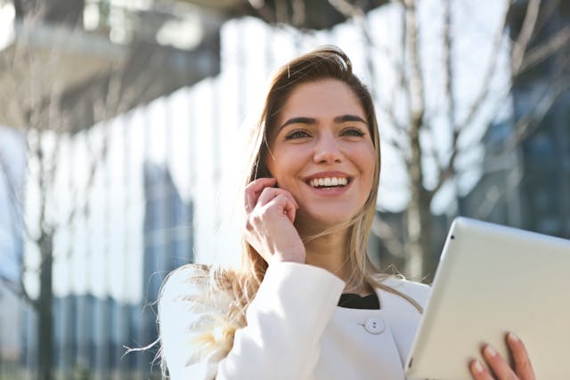 a person holding an ipad while talking on the phone outside