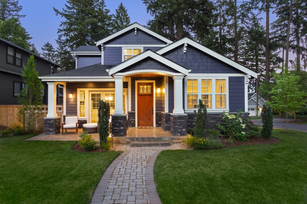 Exterior shot of the front of a blue house with a red door